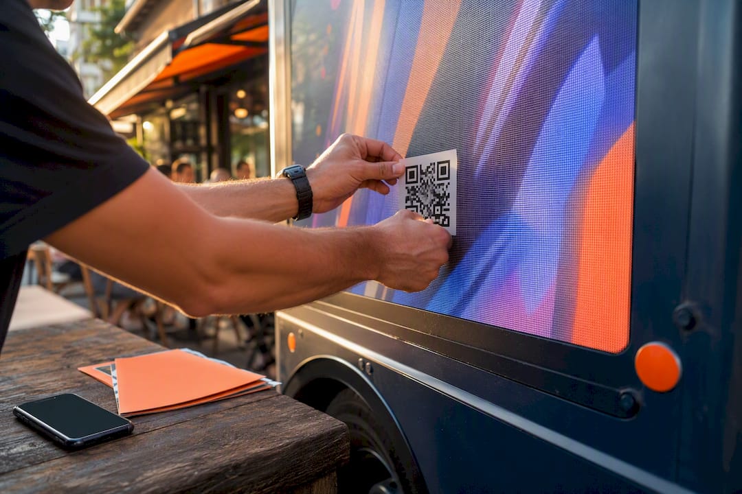 Hands preparing QR code stickers at marketing desk