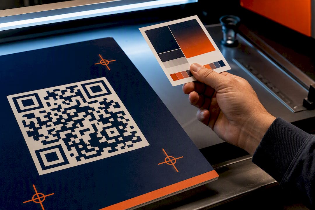 Printed QR campaign proof on production bench