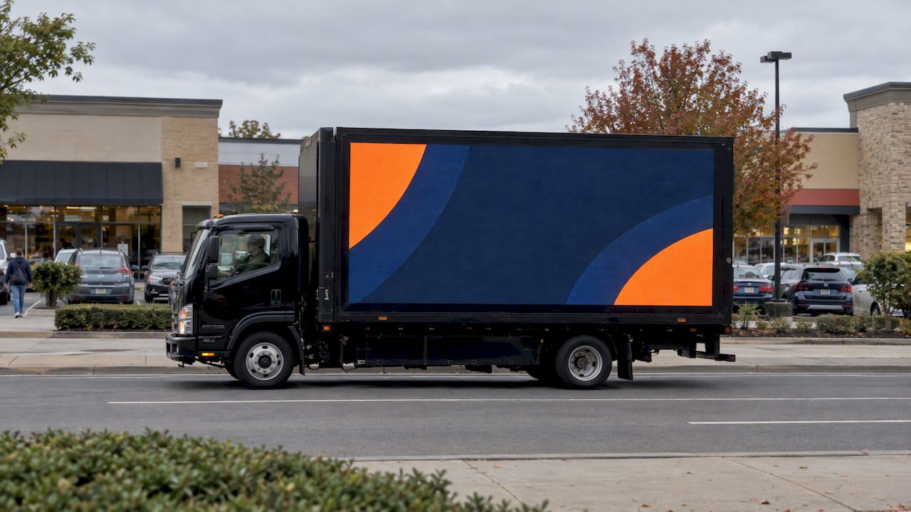 LED mobile billboard truck driving past shops