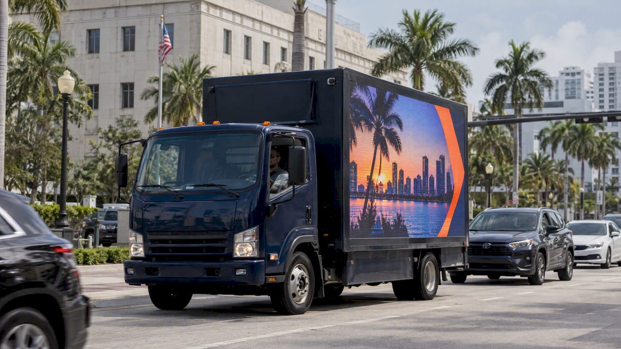 LED billboard truck traveling on a Miami avenue