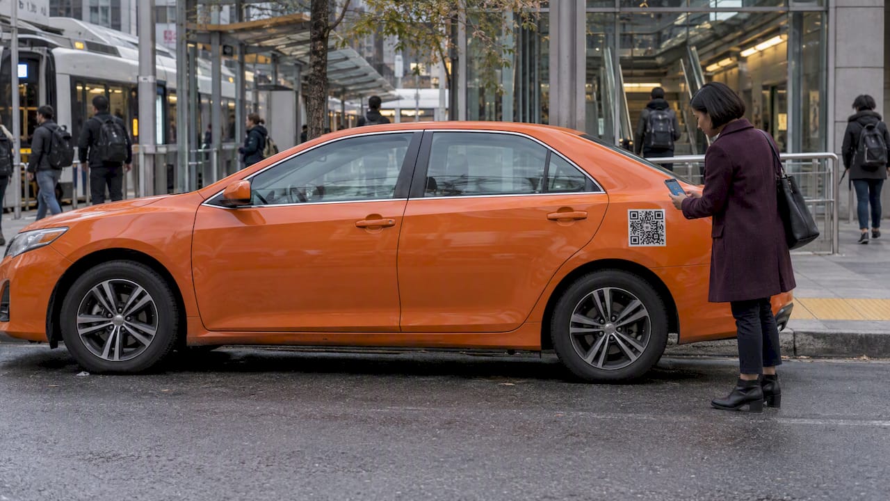 Woman scans QR code on wrapped rideshare car